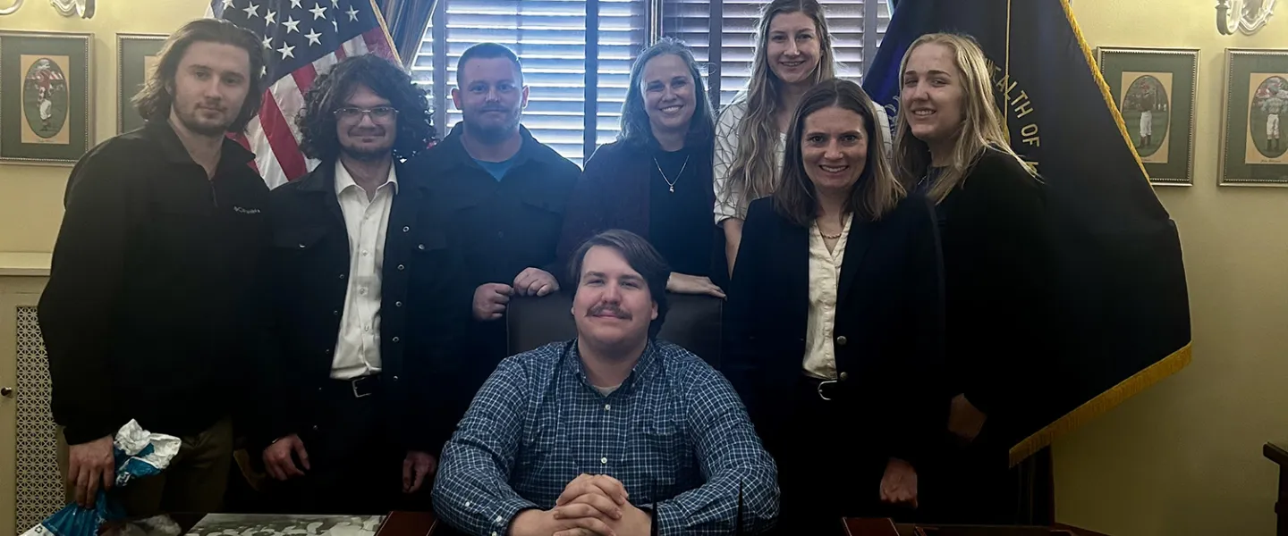 Students from the Upsilon Upsilon honor society at Cumberlands pose behind a desk. 