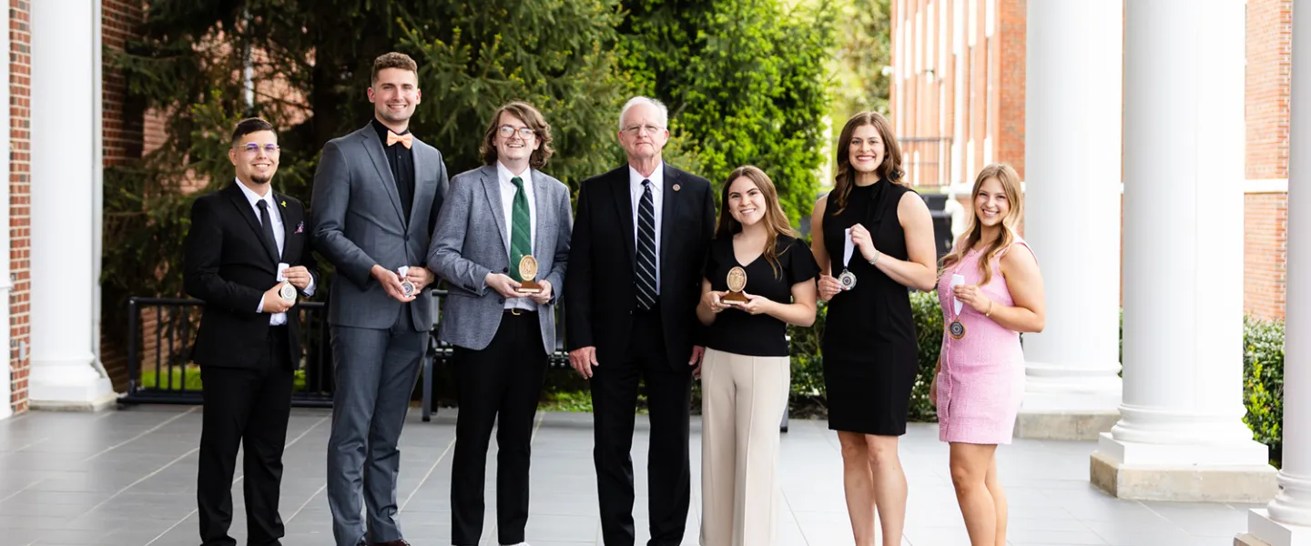 The 2025 academic honors students pose for a photo with President Cockrum.
