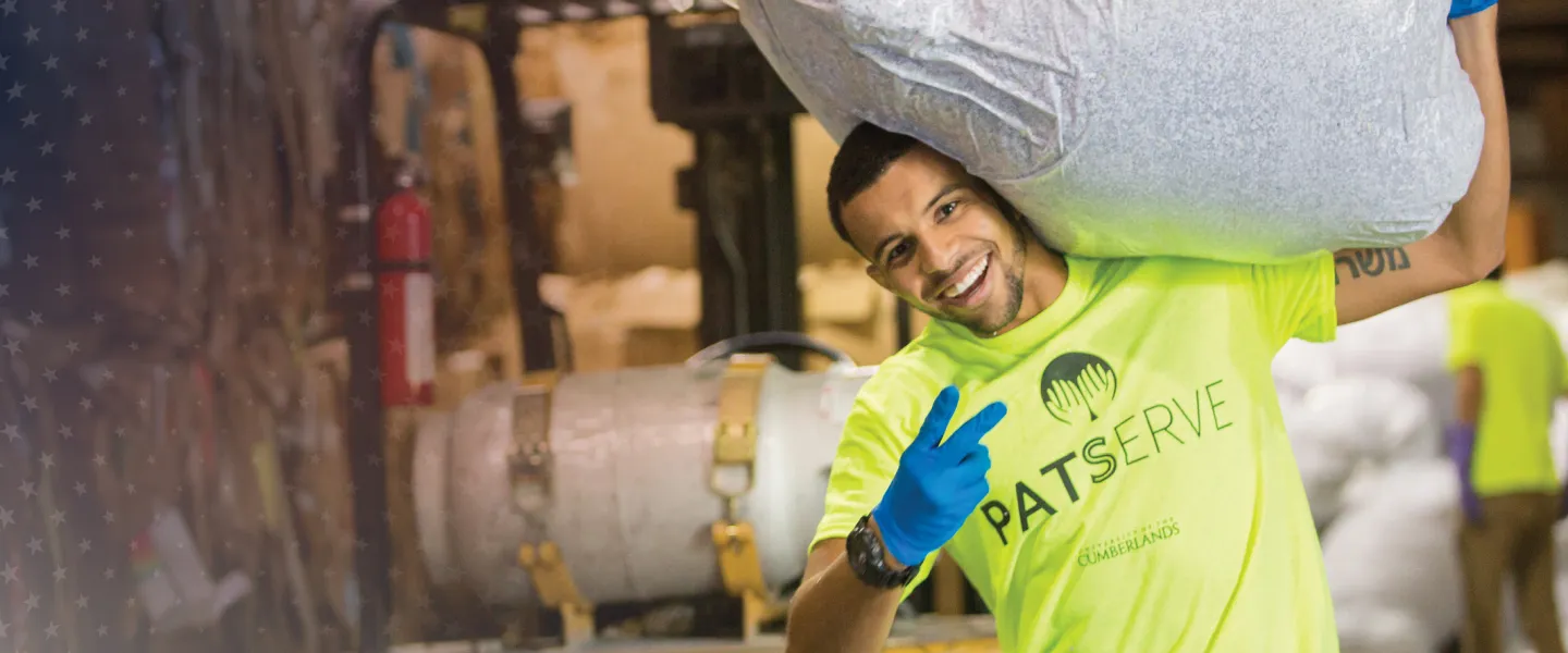 A student carries recycled paper during a service project. 