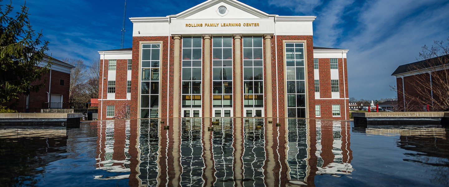 The Rollins Family Learning Center reflecting in the fountain. 