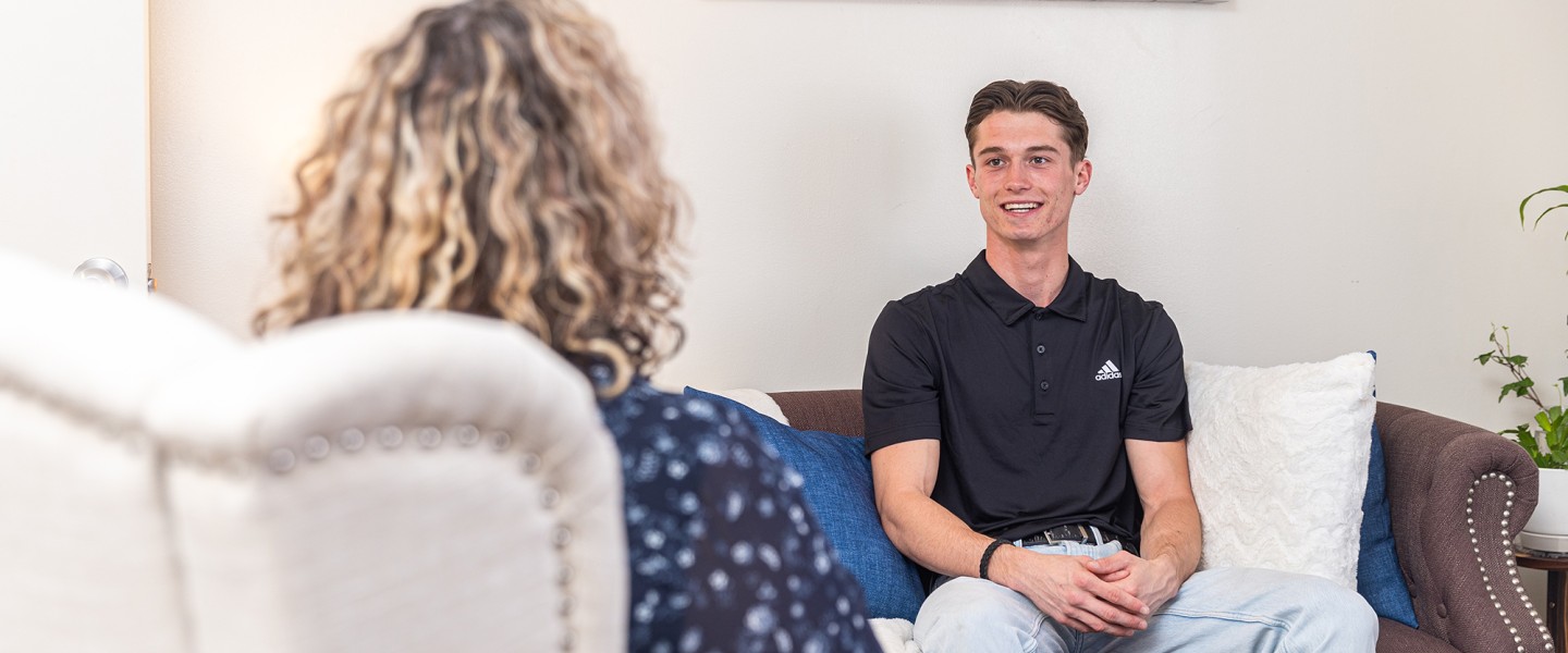 A male student speaks with a counselor during a session at the university's counseling center. 