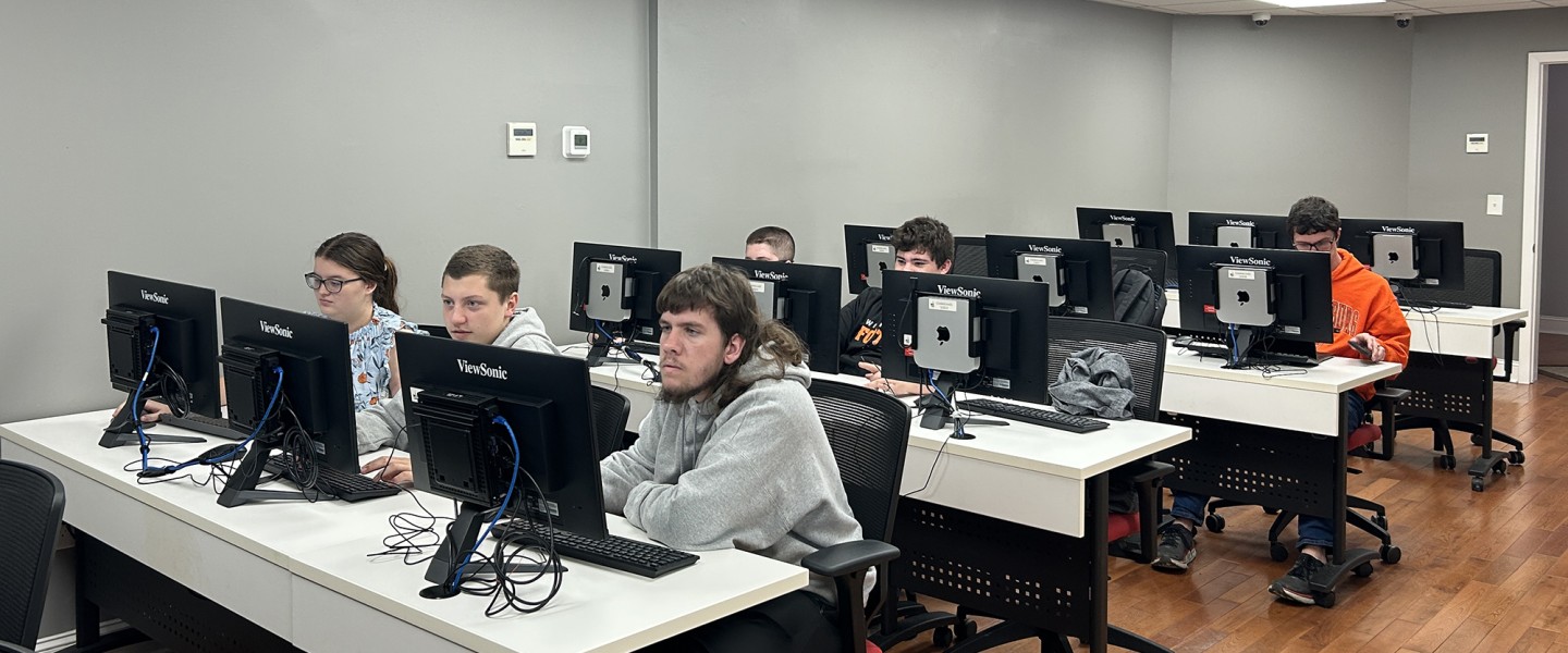Students work on a computer exercise during a Day of Cyber event. 