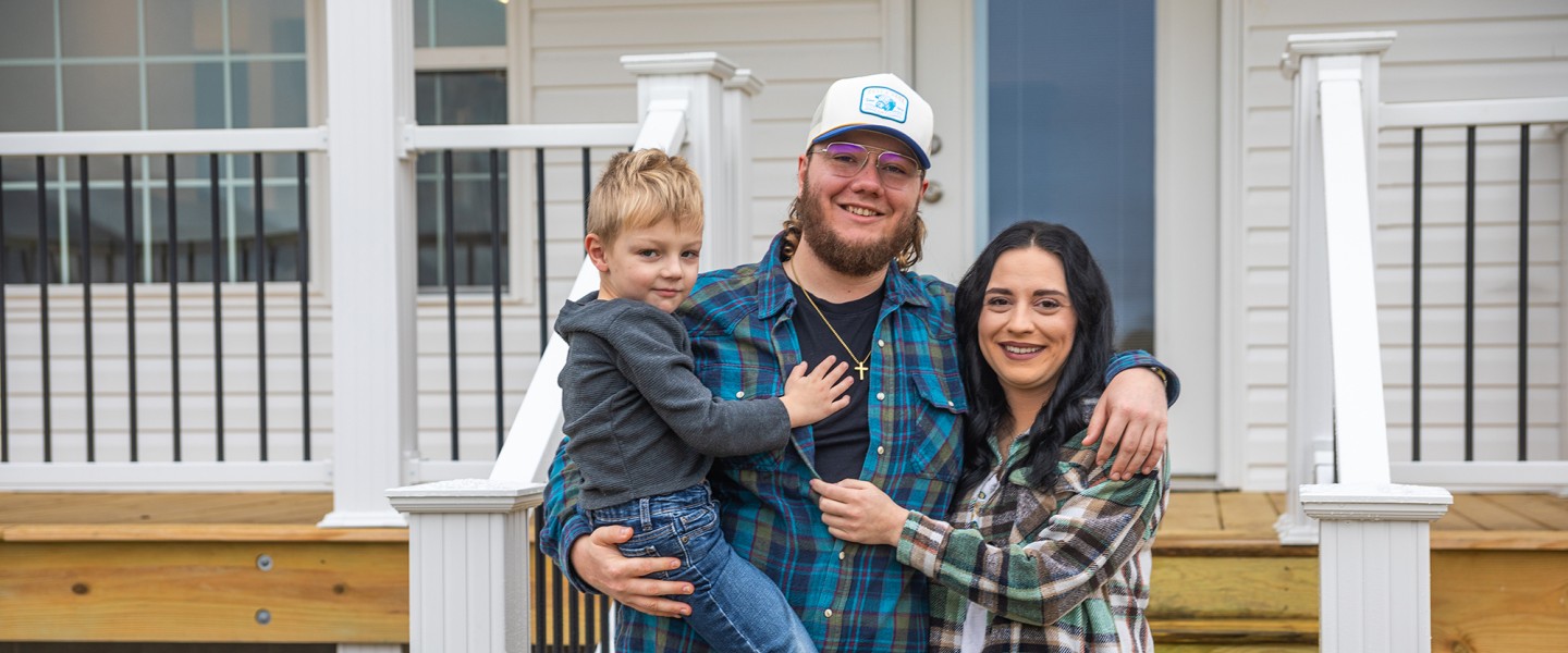 The Perry family poses for a photo in front of a new home constructed by Mountain Outreach. 