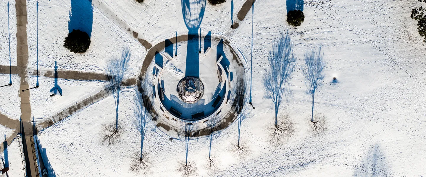 An aerial view of the globe statue on campus after a snow. 