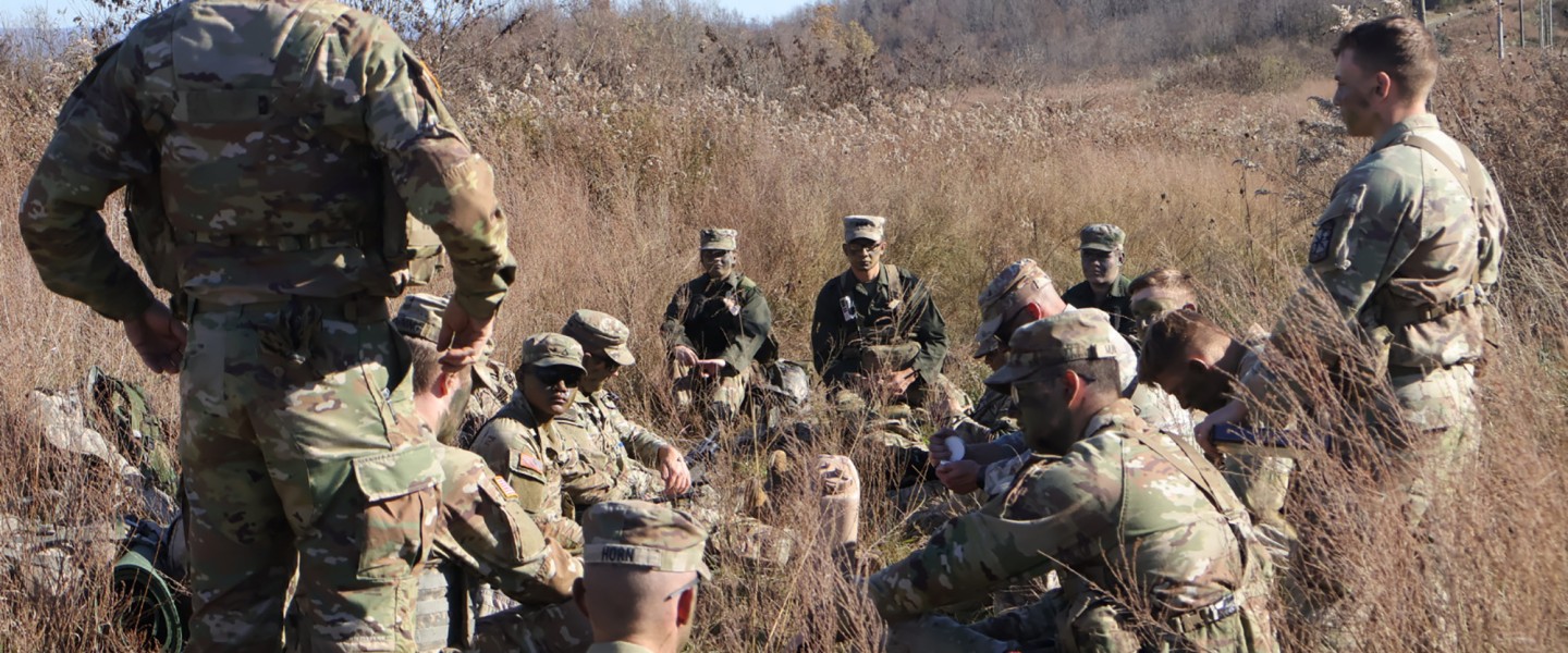 A group of Army ROTC cadets listen to their commander during a field exercise in the fall. 