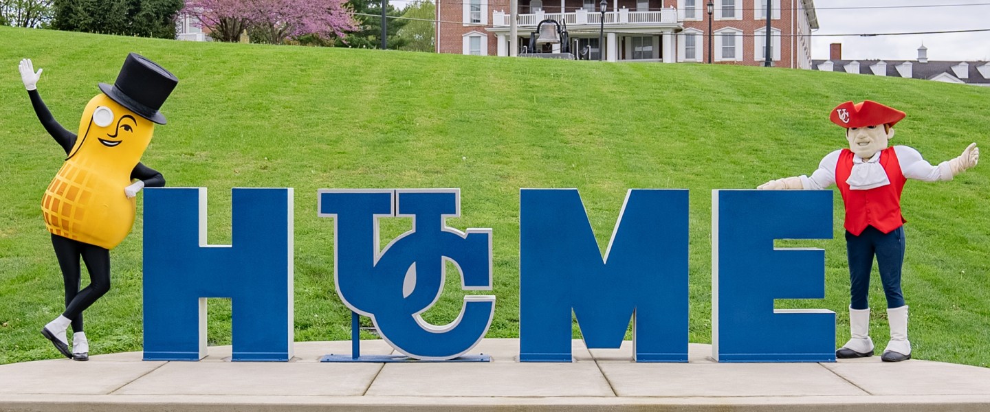 The Mr. Peanut mascot and Cumberlands mascot Patriot Pete stand by the home sign on campus. 
