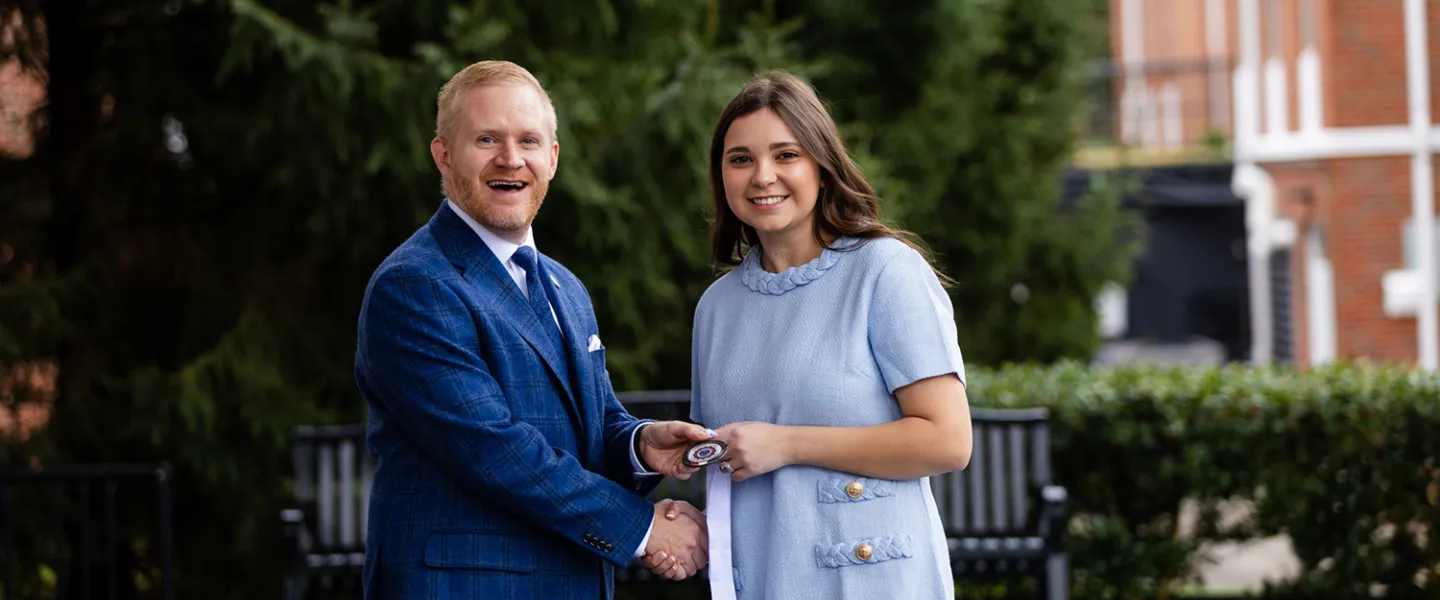 President Young presents a leadership award to student Isabella Watson.