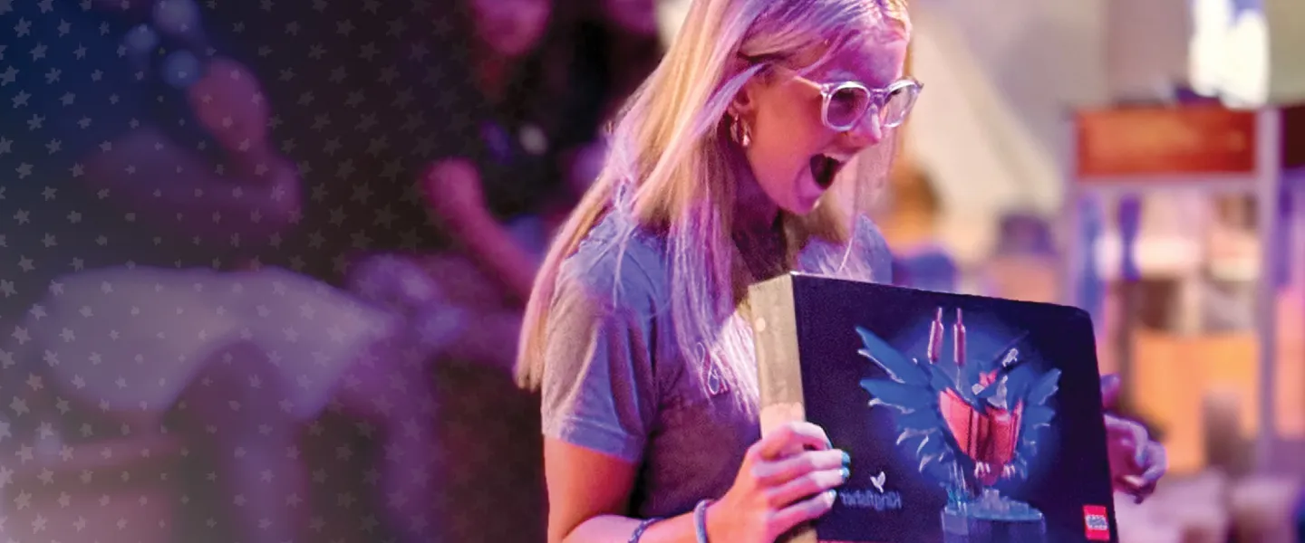 A female holds a Lego set she won during a college orientation event. 