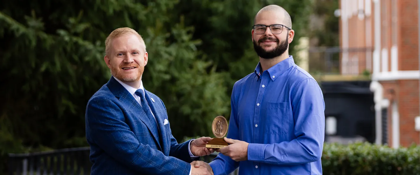 President Young presents a spiritual value award to student Jacob West.