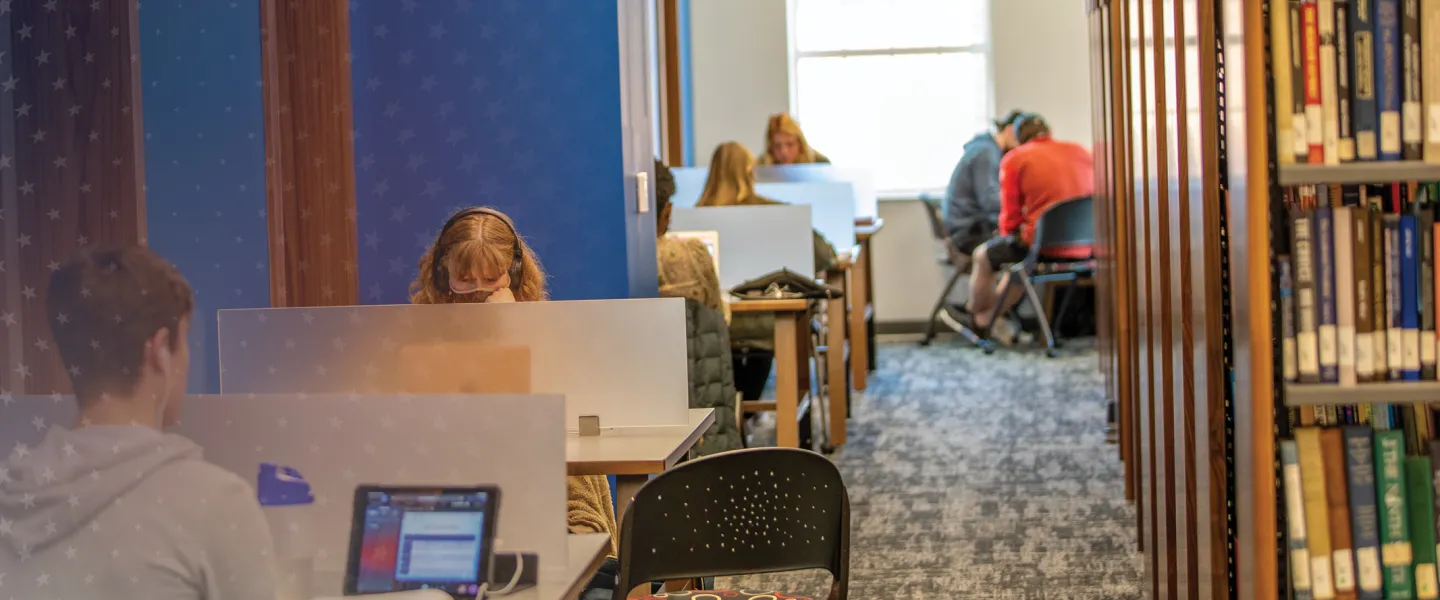 Students sit a kiosks in the library and study. 