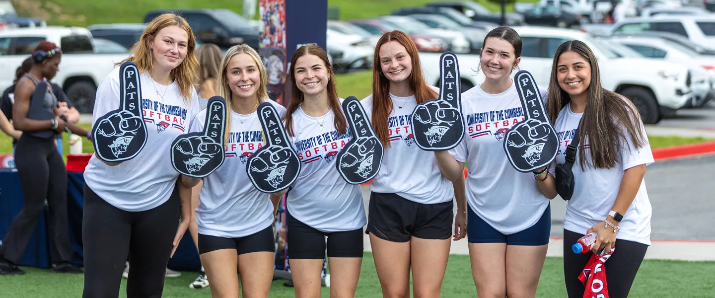Six female students hold up Pats foam fingers during a welcome week event. 