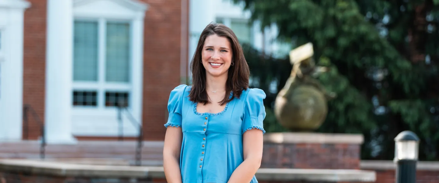 Student Ana Muse poses for a photo in front of the Luecker Building. 