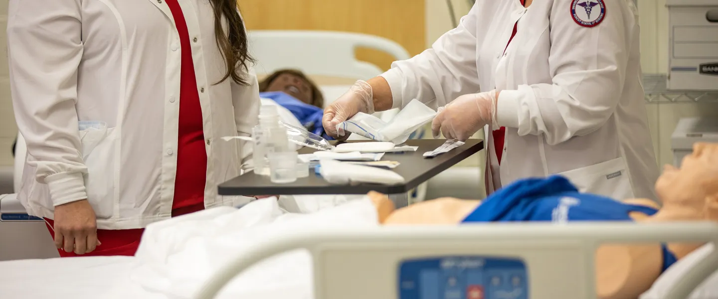 Two nursing students prepare to conduct a clinical examination. 