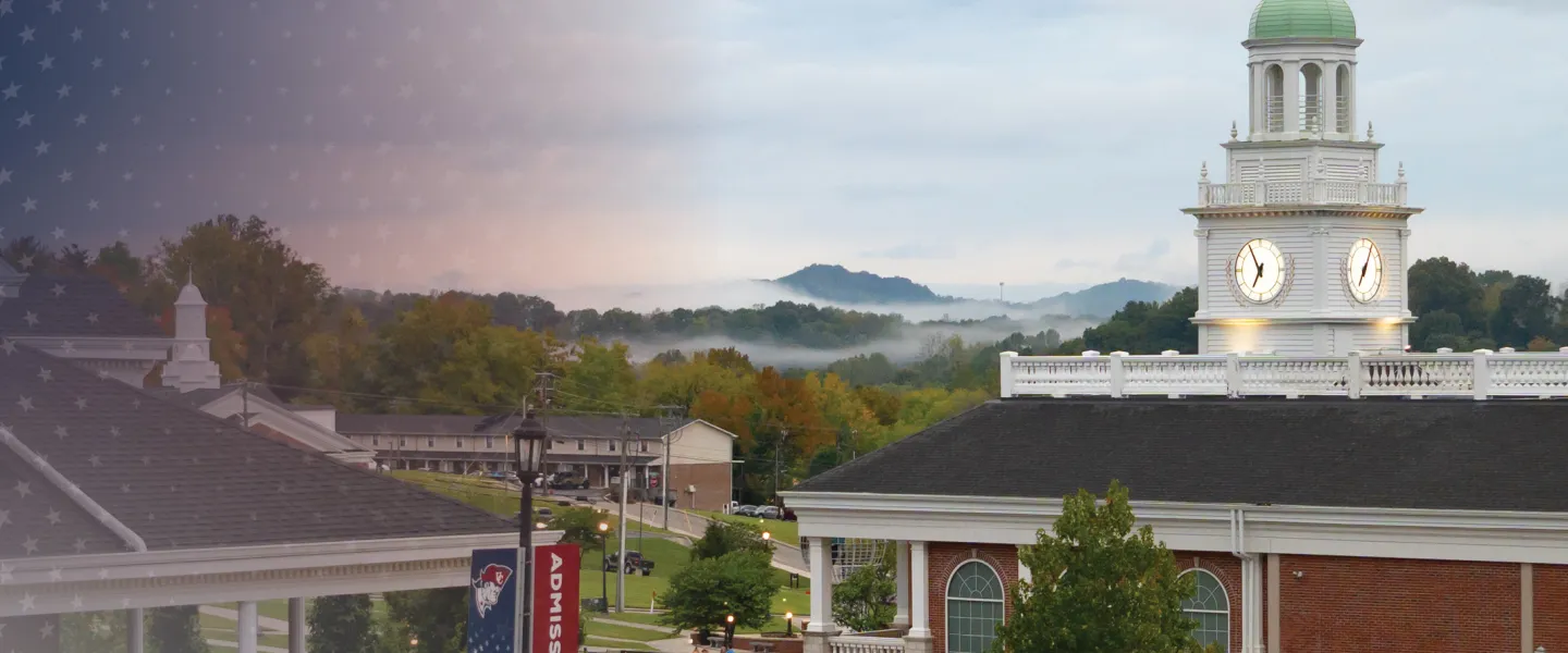 Fog rises above the university campus center during an early fall morning. 