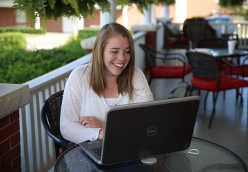 A student on a laptop outside