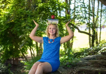 A student balancing books on her head
