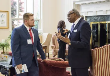 An older man speaking to a young adult