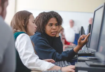 Two students working on a computer together