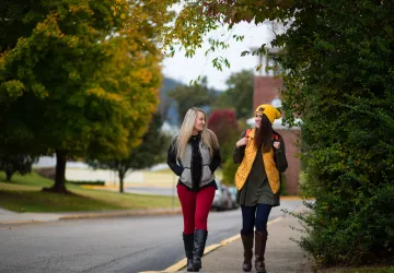 Two students on a sidewalk