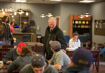 An older man speaking to a young adult