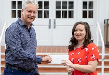 Two people holding an envelope 