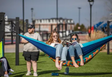Two students sitting on a hammock