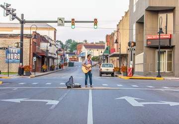 a man playing guitar in the street