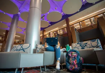 A student using a laptop inside renovated library
