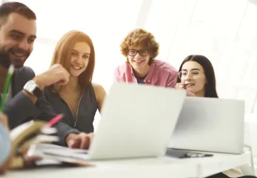 A group of people looking at a laptop
