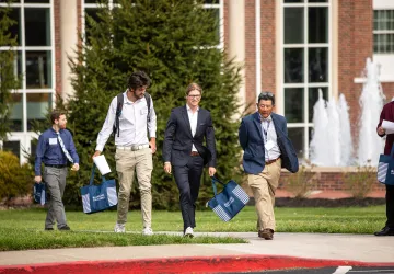 Students speak with a business professor following the annual forum. 