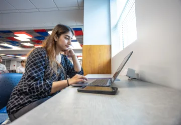 A graduate business student studies in the library. 