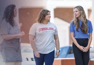 Students walk on campus while discussing their day. 