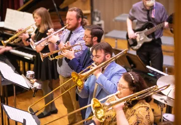 Band students practice a musical selection in the university recital hall. 
