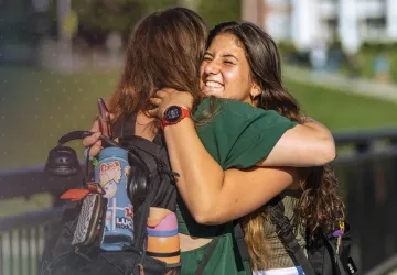 Students hug on their way to class. 