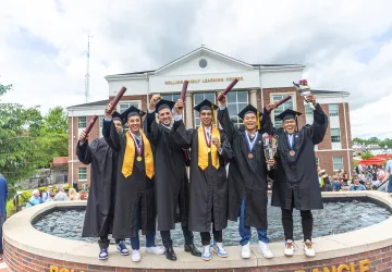 Students celebrate with their diploma following graduation.