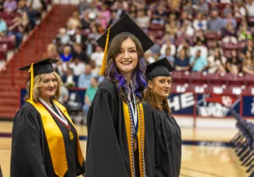 A student walks into her graduation ceremony. 