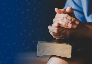 Clasped Hands Over Bible