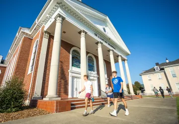 Students walk in front of the chapel on campus.