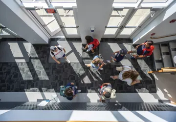 Students walk through the foyer of the library. 