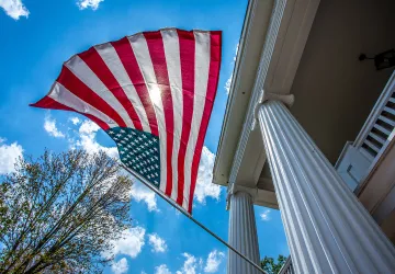 An American flag is displayed on a building on campus. 