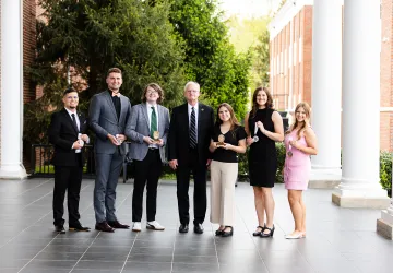 The 2025 academic honors students pose for a photo with President Cockrum.