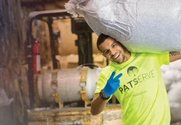 A student carries recycled paper during a service project. 