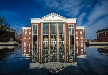 The Rollins Family Learning Center reflecting in the fountain. 