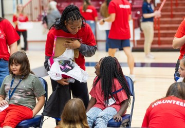 A female college volunteer shows a local female elementary student a new pair of shoes during Cumberlands annual service event. 