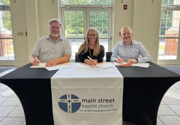 Officials from Main Street Baptist, Williamsburg Independent School, and University of the Cumberlands sign an agreement to operate an early childhood center. 