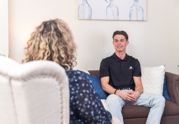 A male student speaks with a counselor during a session at the university's counseling center. 