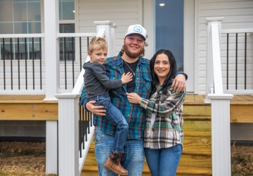 The Perry family poses for a photo in front of a new home constructed by Mountain Outreach. 