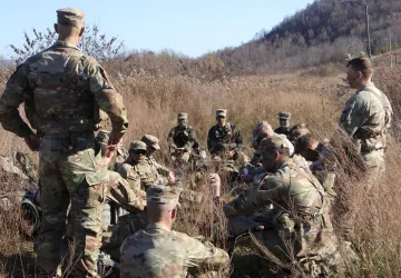 A group of Army ROTC cadets listen to their commander during a field exercise in the fall. 