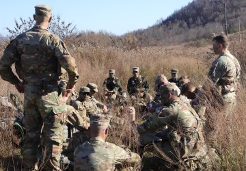 A group of Army ROTC cadets listen to their commander during a field exercise in the fall. 