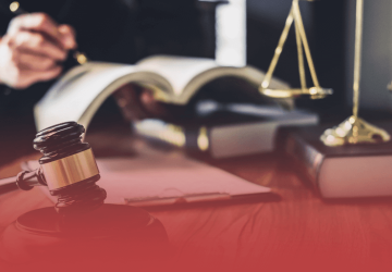 Judge Writing in Book with Gavel and Scales in Foreground